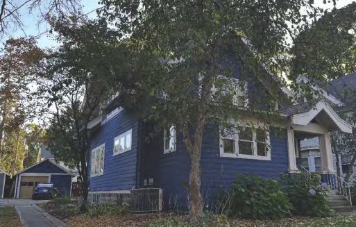 Blue two-story wood-sided house at 1717 Chadbourne Avenue with mature trees and detached garage.